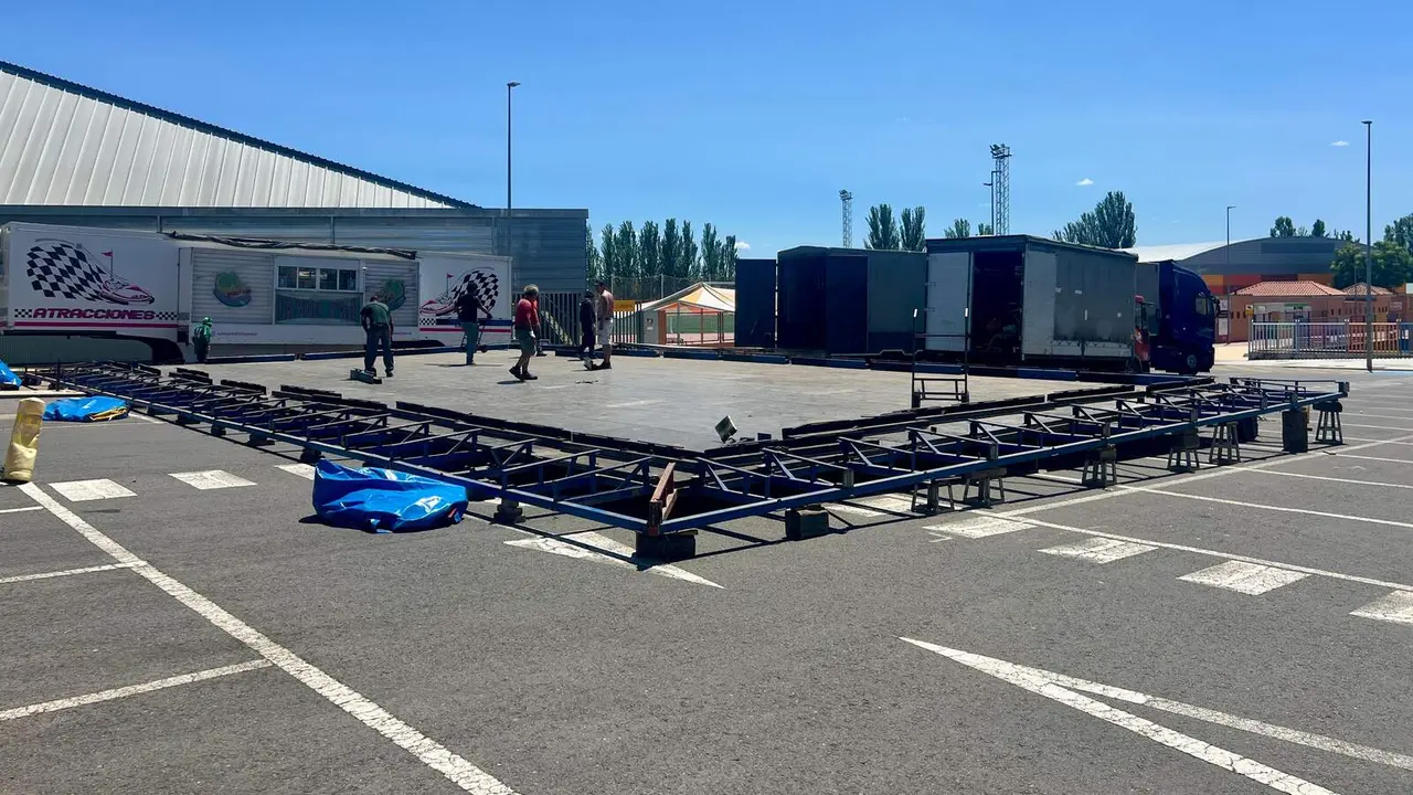 Operarios durante el montaje de los coches de choque en el Recinto Ferial.